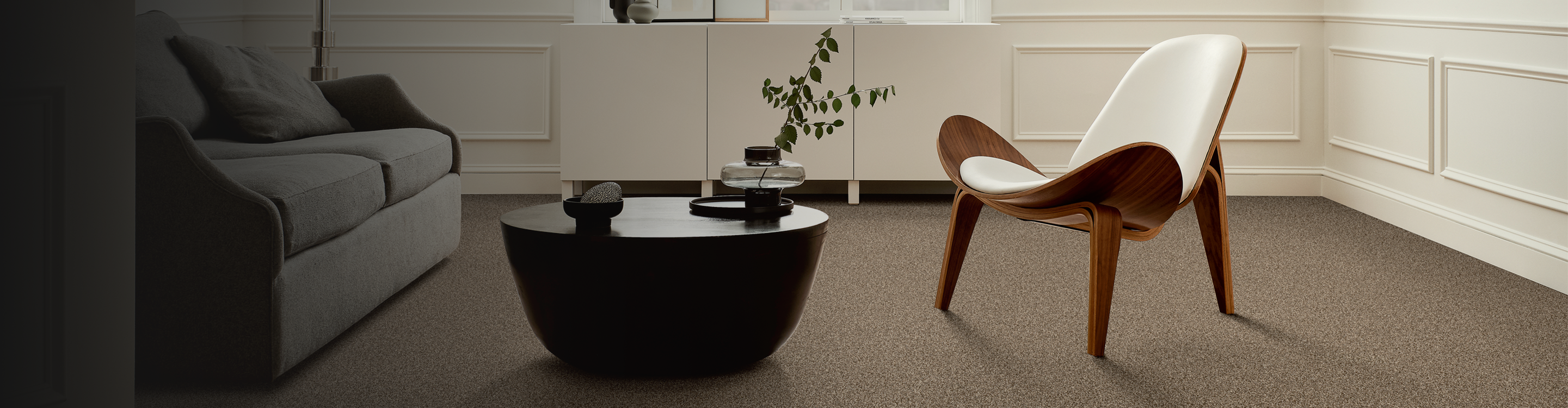 brown textured carpets in a Northport living room with couch, coffee table, and and statement chair